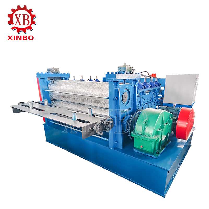 A blue metal embossing machine has a central pair of patterned rollers, a sheet feed table, and a control cabinet.